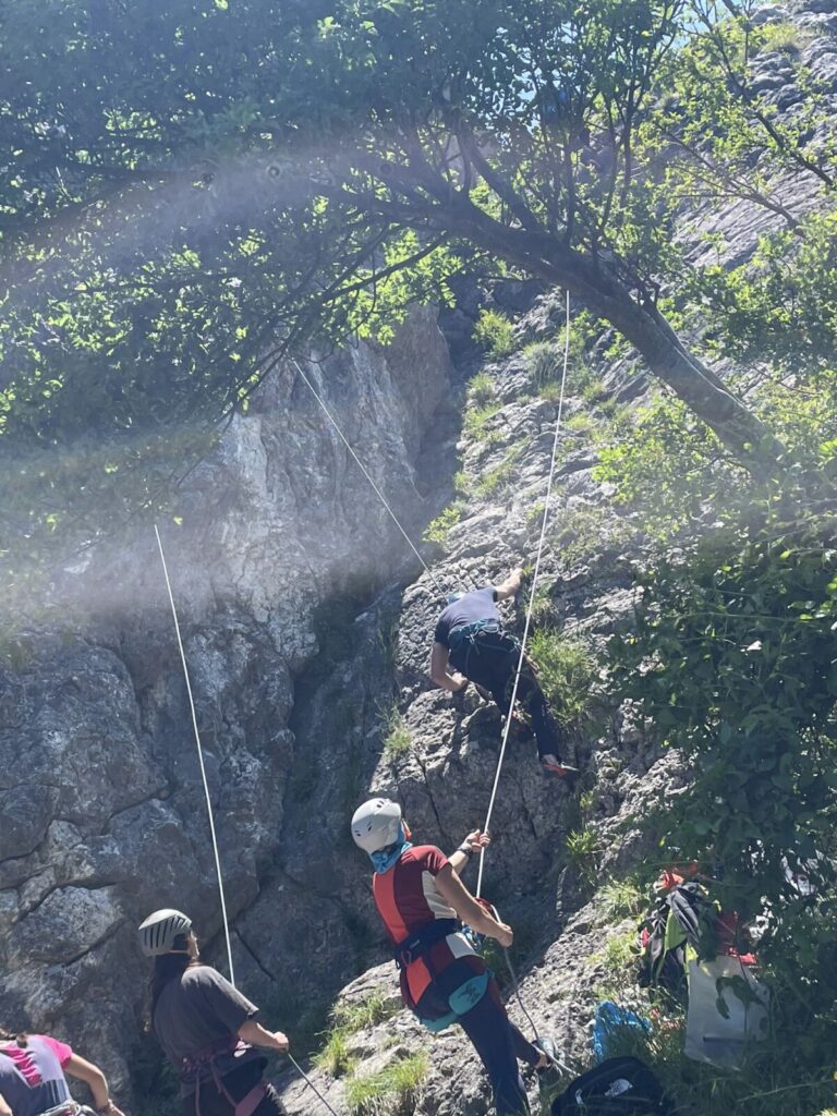 Arrampicatore su roccia nel bosco durante un corso