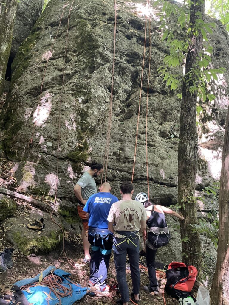 Gruppo di allievi alla base della falesia durante un corso di arrampicata